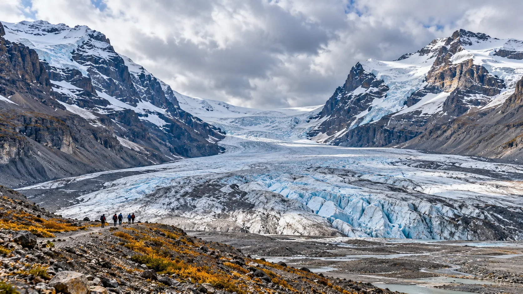 Hikers approaching Athabasca Glacier with massive ice walls and moraine in foreground